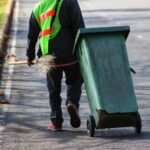 junkisremoved worker collecting trash bins during professional waste removal service